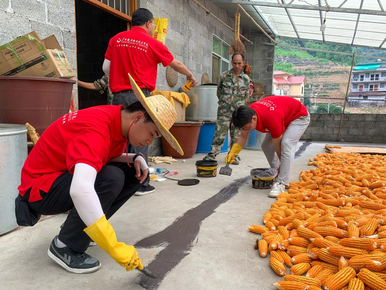 實(shí)踐團(tuán)成員在房頂裂縫處涂抹防水涂料