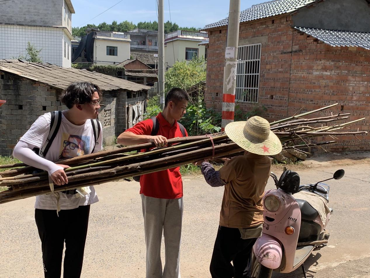 觀察團(tuán)成員幫助村民搬運(yùn)重物