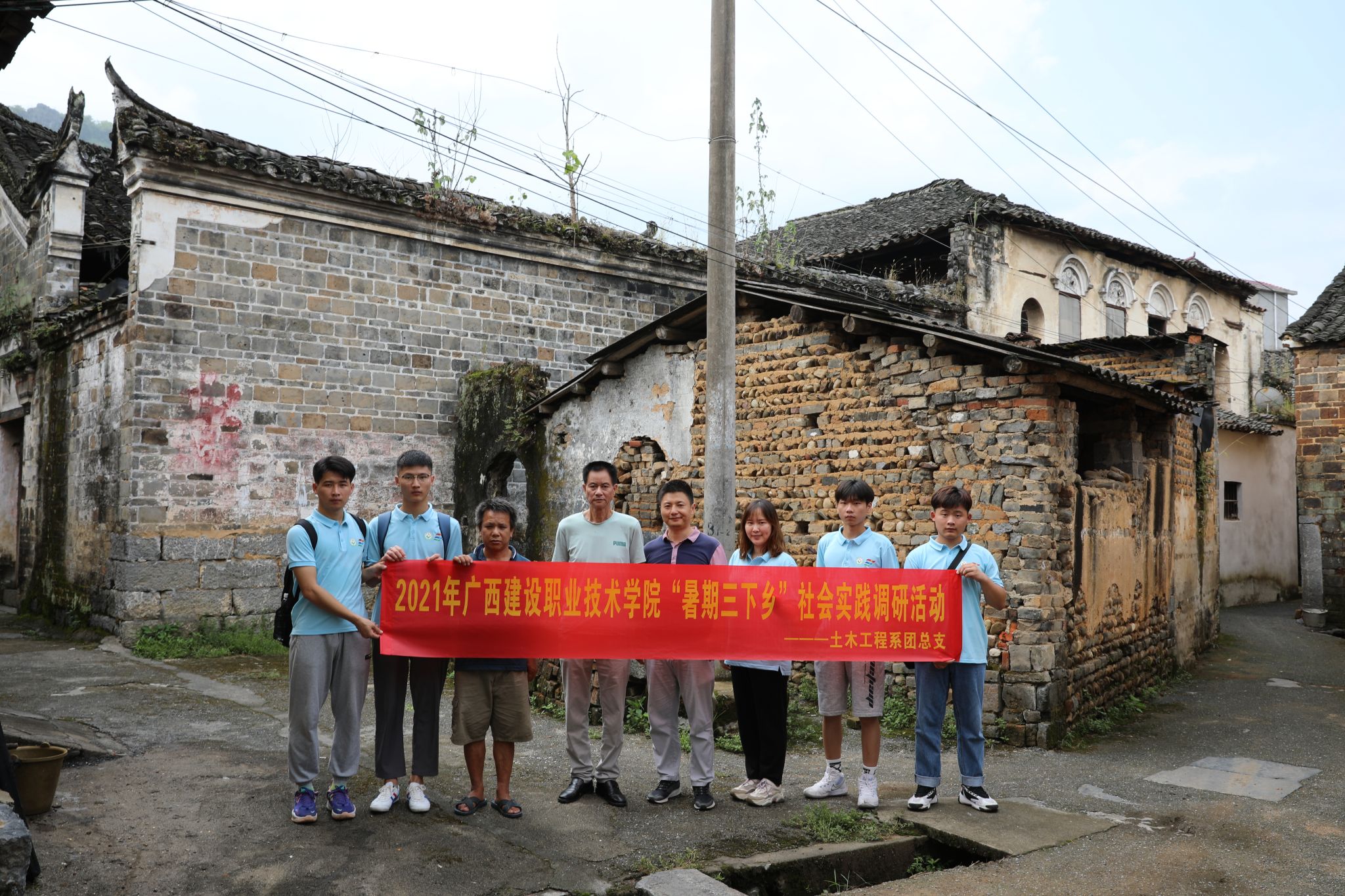 實踐團(tuán)成員在歷史民居前與石腳村村民合影