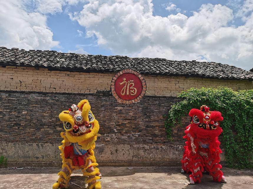實踐團(tuán)成員在村落古建筑處舞獅