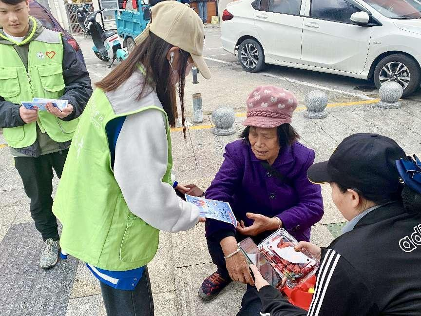 志愿者向西鄉(xiāng)塘客運站周圍行人宣傳防范保健品詐騙的安全知識