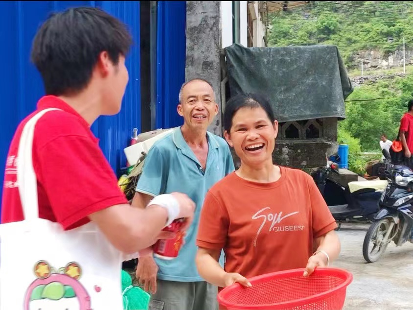 實(shí)踐團(tuán)成員為村民修補(bǔ)好漏水屋頂后，村民露出了滿意的笑容