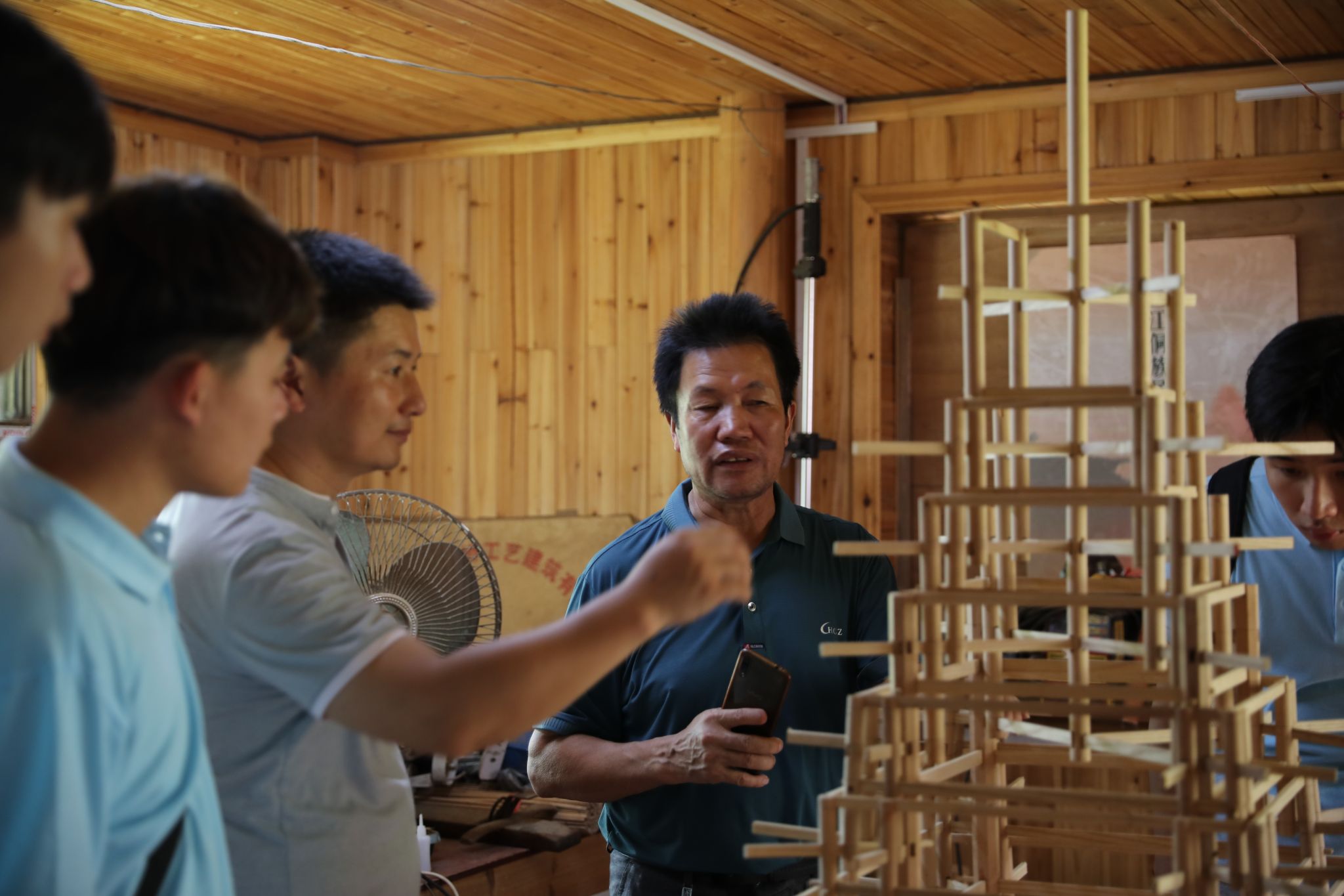 楊似玉大師利用鼓樓模型向?qū)嵺`團(tuán)成員解說鼓樓建筑結(jié)構(gòu)